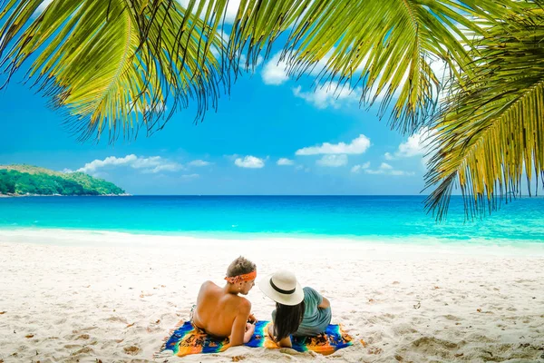 Praia branca tropical na ilha de Praslin Seychelles, feliz casal jovem homem e mulher durante as férias Férias na praia relaxando sob uma palmeira — Fotografia de Stock