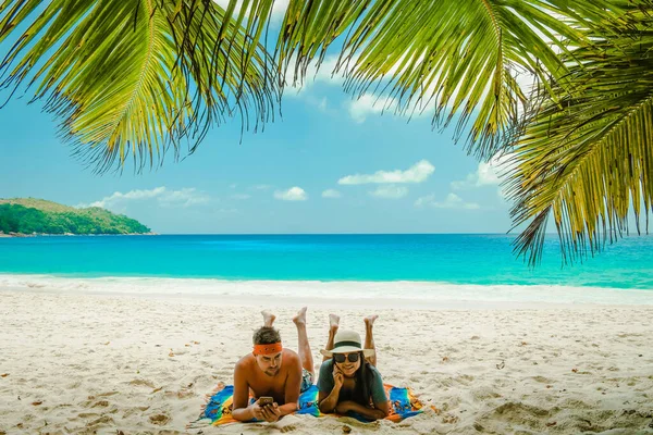 Tropischer weißer Strand auf der Insel Praslin Seychellen, glückliches junges Paar im Urlaub Urlaub Urlaub am Strand unter einer Palme — Stockfoto