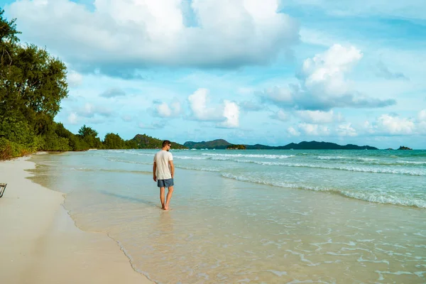 Praslin Seychelles, hombres jóvenes en la playa tropical con palmera, hombre blanco de la playa caminando Seychelles Island, hombres bronceadores en vacaciones tropicales — Foto de Stock
