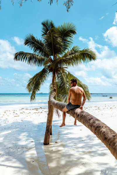 Praslin Seychely, mladí muži na tropické pláži s palmami, bílý plážový muž na procházce Seychely Island, opalování muži na tropické dovolené — Stock fotografie