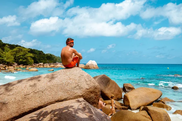 Praslin Seychely, mladí muži na tropické pláži s palmami, bílý plážový muž na procházce Seychely Island, opalování muži na tropické dovolené — Stock fotografie