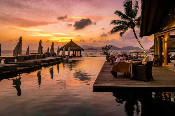 Lyxig pool i tropisk resort, avkopplande semester i Seychellerna öar. La Digue, solnedgång vid poolen — Stockfoto