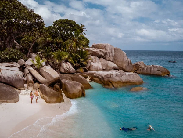 セイシェル熱帯の島、プラリンズ島ヤシの木と熱帯のビーチを歩くカップルとセイシェル — ストック写真