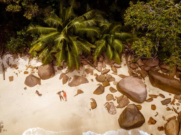 Ilhas tropicais das Seychelles, Ilha Praslins Seychelles com casal caminhando na praia tropical com palmeiras — Fotografia de Stock