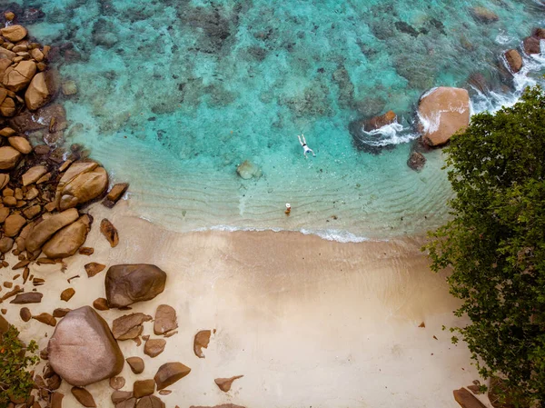 Seychellerna tropiska öar, Praslins Island Seychellerna med par promenader på den tropiska stranden med palmer — Stockfoto