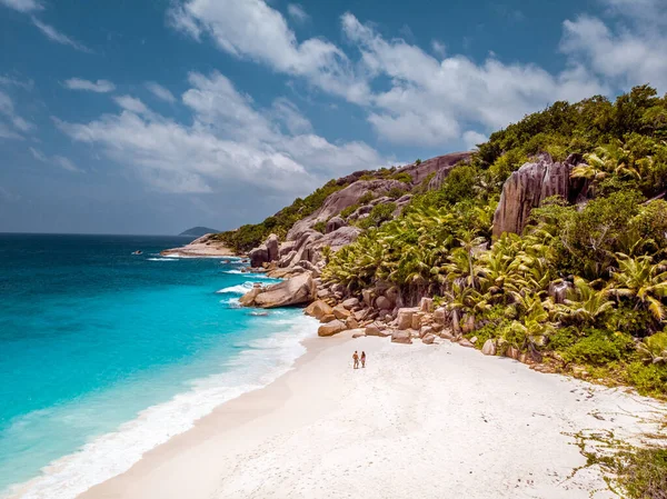 Seychelles isole tropicali, Isola di Praslins Seychelles con coppia che cammina sulla spiaggia tropicale con palme — Foto Stock