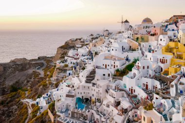 Santorini Oia Köyü günbatımında beyaz oteller ve Santorini Adası 'ndaki beyaz boyalı binalar Yunanistan' da lüks bir tatil beldesi.