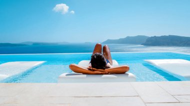 Yunanistan 'da tatil yapan Yunanistan' da Oia Santorini, Yunanistan 'da tatil yapan Yunanistan' da Yunan kiliseleriyle beyazlatılmış köye lüks bir gezi düzenleyen kadın.