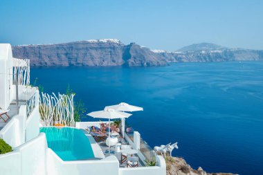 Santorini Oia Köyü günbatımında beyaz oteller ve Santorini Adası 'ndaki beyaz boyalı binalar Yunanistan' da lüks bir tatil beldesi.