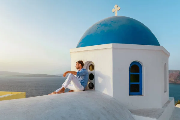 Hombre de vacaciones Grecia visisting Oia Santorini, chico de vacaciones en Grecia en un viaje de lujo a Oia pueblo encalado con iglesias griegas — Foto de Stock