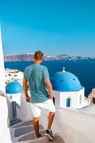 Mann im Urlaub Griechenland zu Besuch in Oia Santorini, Mann im Urlaub in Griechenland auf einer Luxusreise nach Oia weiß getünchten Dorf mit griechischen Kirchen — Stockfoto