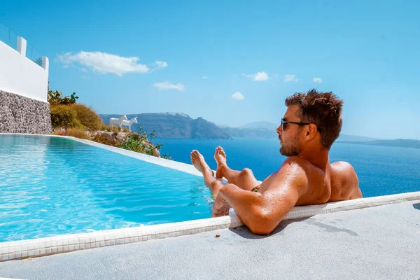 Yunanistan 'da tatil yapan Yunanistan' da Oia Santorini, Yunanistan 'da tatil yapan Yunanistan' da Yunan kiliseleri olan Oia beyazlatılmış köye lüks bir gezi düzenleyen adam. — Stok fotoğraf