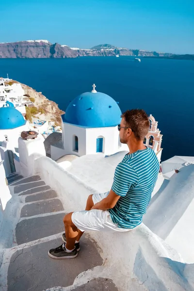 Mann im Urlaub Griechenland zu Besuch in Oia Santorini, Mann im Urlaub in Griechenland auf einer Luxusreise nach Oia weiß getünchten Dorf mit griechischen Kirchen — Stockfoto