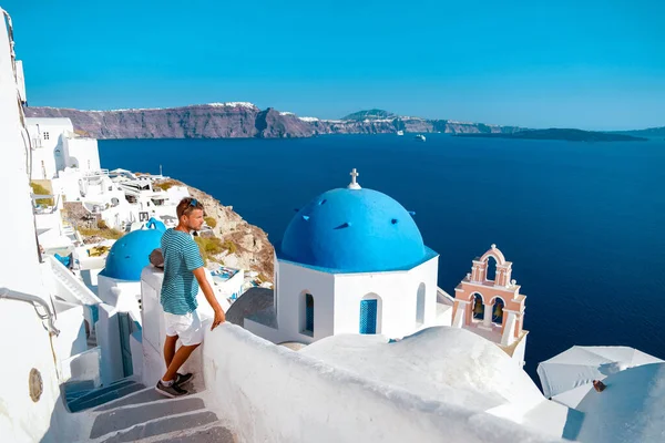 Mann im Urlaub Griechenland zu Besuch in Oia Santorini, Mann im Urlaub in Griechenland auf einer Luxusreise nach Oia weiß getünchten Dorf mit griechischen Kirchen — Stockfoto