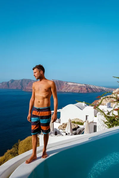 Mężczyzna na wakacjach Grecja odwiedza Oia Santorini, facet na wakacjach w Grecji na luksusowej wycieczce do wioski Oia bielone z greckimi kościołami — Zdjęcie stockowe