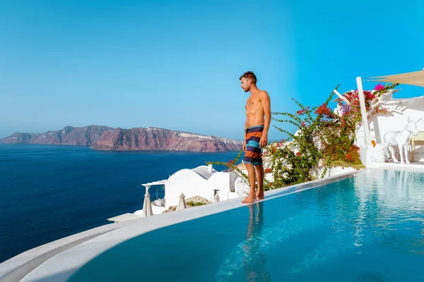 Mężczyzna na wakacjach Grecja odwiedza Oia Santorini, facet na wakacjach w Grecji na luksusowej wycieczce do wioski Oia bielone z greckimi kościołami — Zdjęcie stockowe