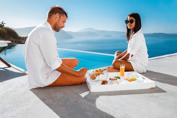 Pareja luna de miel de vacaciones Grecia visisting Oia Santorini, hombre y chica de vacaciones en Grecia en un viaje de lujo a Oia pueblo encalado con iglesias griegas —  Fotos de Stock