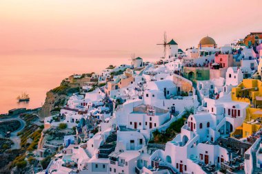 Santorini Oia Köyü günbatımında beyaz oteller ve Santorini Adası 'ndaki beyaz boyalı binalar Yunanistan' da lüks bir tatil beldesi.