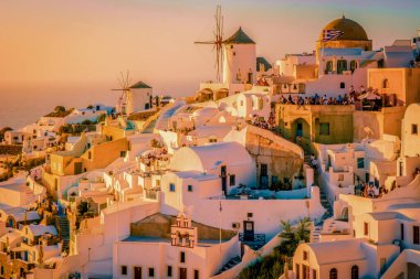 Santorini Oia Köyü günbatımında beyaz oteller ve Santorini Adası 'ndaki beyaz boyalı binalar Yunanistan' da lüks bir tatil beldesi.