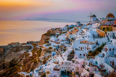 Santorini Oia Köyü günbatımında beyaz oteller ve Santorini Adası 'ndaki beyaz boyalı binalar Yunanistan' da lüks bir tatil beldesi.