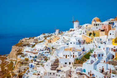 Santorini Oia Köyü günbatımında beyaz oteller ve Santorini Adası 'ndaki beyaz boyalı binalar Yunanistan' da lüks bir tatil beldesi.