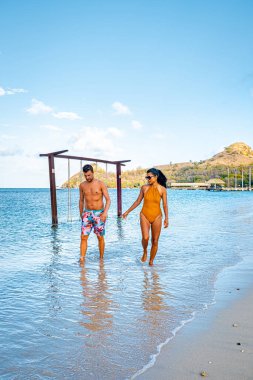 Saint Lucia Karayip Adası, Saint Lucia tropikal adasında lüks içinde bir çift, plaj kenarında erkek ve kadın ve kristal berrak okyanus St. Lucia Karayip bayramı