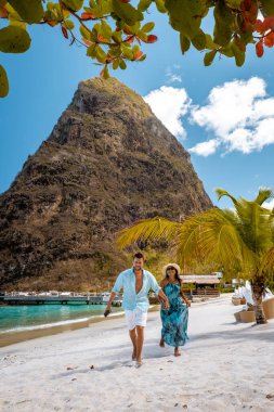Saint Lucia Karayip Adası, Saint Lucia tropikal adasında lüks içinde bir çift, plaj kenarında erkek ve kadın ve kristal berrak okyanus St. Lucia Karayip bayramı