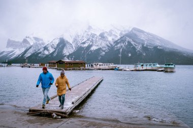 Minnewanka Gölü Ulusal Parkı Kanada, çift ekim ayında Kanada 'da kar fırtınası sırasında göl kenarında yürüyor 