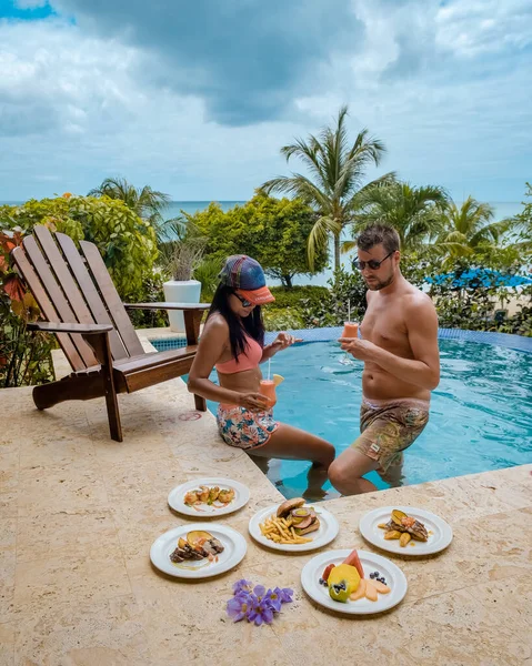 St Lucia caribbean, couple on vacation at Saint Lucia, men and woman in luxury resort during lunch with a look at the ocean and beach — 스톡 사진