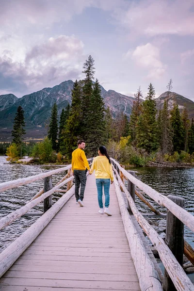 Pareja por el lago viendo la puesta del sol, Pirámide lago Jasper durante el otoño en Alberta Canadá, caída de colores por el lago durante la puesta del sol, Pirámide isla Jasper —  Fotos de Stock