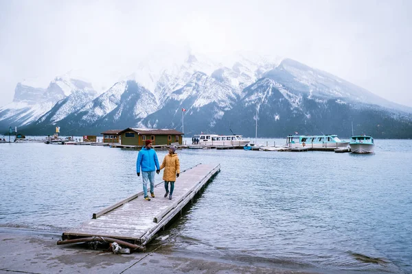 Озеро Минневанка Банф Национальный парк Канада, пара прогулок по озеру во время снежной бури в октябре в канадских Скалистых горах Канады — стоковое фото