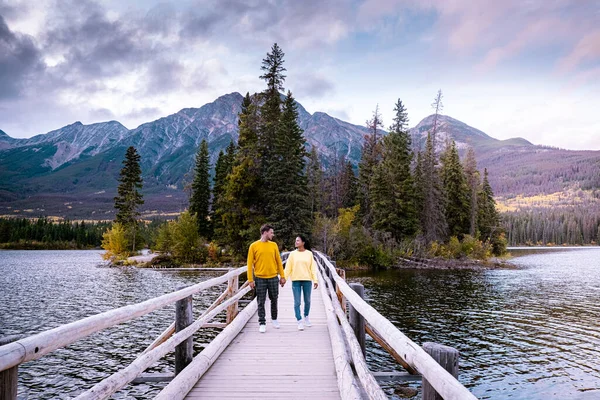 Casal pelo lago assistindo por do sol, Pirâmide lago Jasper durante o outono em Alberta Canadá, cores de outono pelo lago durante o pôr do sol, Pirâmide ilha Jasper — Fotografia de Stock