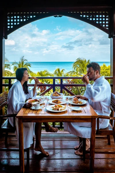 St Lucia caribbean, couple on vacation at Saint Lucia, men and woman in luxury resort during lunch with a look at the ocean and beach — Stockfoto