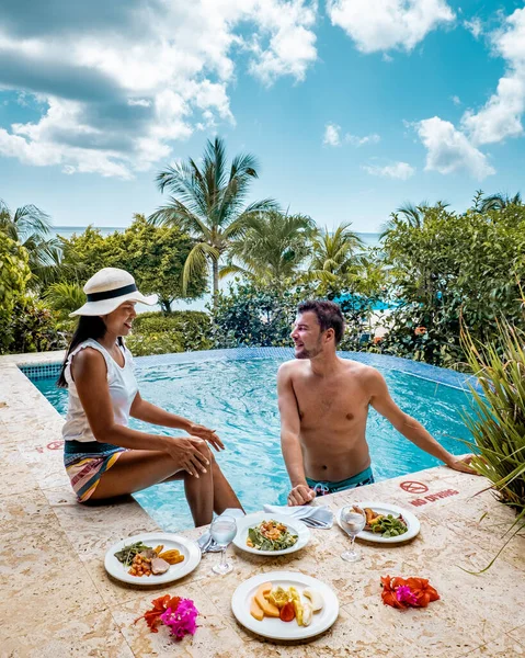 Santa Lucía caribe, pareja de vacaciones en Santa Lucía, hombres y mujeres en un resort de lujo durante el almuerzo con una mirada al océano y la playa —  Fotos de Stock