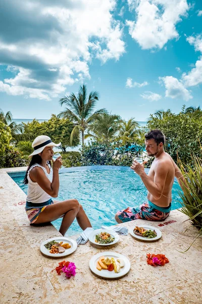 Santa Lucía caribe, pareja de vacaciones en Santa Lucía, hombres y mujeres en un resort de lujo durante el almuerzo con una mirada al océano y la playa —  Fotos de Stock