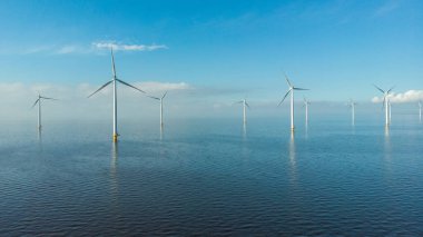 Hollanda Gölü kıyısındaki yel değirmeni sıraları yenilenebilir enerji yel değirmeni çiftliği Flevoland