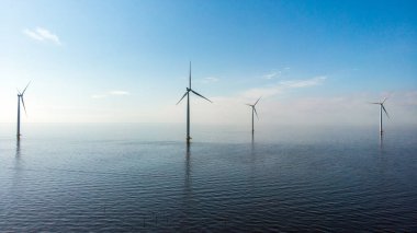 Hollanda Gölü kıyısındaki yel değirmeni sıraları yenilenebilir enerji yel değirmeni çiftliği Flevoland
