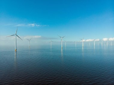 Hollanda Gölü kıyısındaki yel değirmeni sıraları yenilenebilir enerji yel değirmeni çiftliği Flevoland