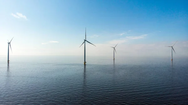 Windmolenrij windmolens in de oceaan aan het IJsselmeer Nederland, duurzame energie windmolenpark Flevoland — Stockfoto