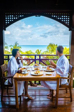 St Lucia caribbean, couple on vacation at Saint Lucia, men and woman in luxury resort during lunch with a look at the ocean and beach