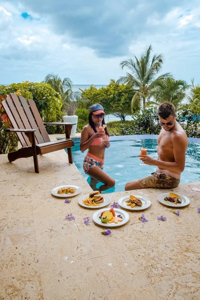 St Lucia caribbean, couple on vacation at Saint Lucia, men and woman in luxury resort during lunch with a look at the ocean and beach — 스톡 사진