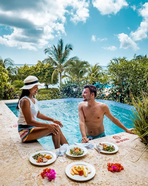 St Lucia caribbean, couple on vacation at Saint Lucia, men and woman in luxury resort during lunch with a look at the ocean and beach — Φωτογραφία Αρχείου