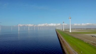 Hollanda Gölü kıyısındaki yel değirmeni sıraları yenilenebilir enerji yel değirmeni çiftliği Flevoland