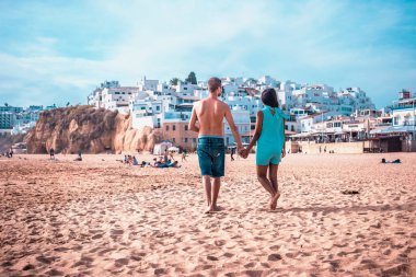 Mutlu genç çift Albufeira Algarve Portekiz sahillerinde yürüyor.