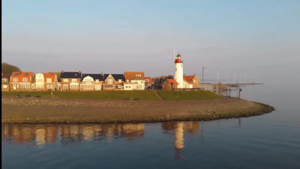 位于前岛屿Urk Flevoland Netherlands旁边的Ijsselmeer湖石滩上的荨麻疹灯塔，鸟瞰着Urk古老的杜奇村 — 图库视频影像