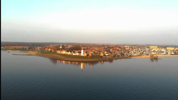 Urk Flevoland Hollanda 'daki Ijsselmeer Gölü kıyısındaki kayalık sahilde deniz feneri. Eski Alman köyü Urk' un kuş bakışı insansız hava aracı görüntüsü. — Stok video