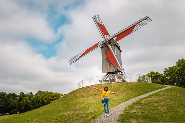 Brugge Belgium, colorful house at the old city of Brugge , young woman free in the city by the old windmill,Bruges, Belgium. Sint Janshuismolen wind mill dating from 1770, still in its original spot — Stock Photo, Image