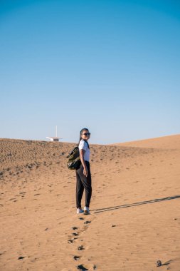 Maspalomas sahilinde yürüyen kadın Gran Canaria İspanya 'da, Maspaloma' nın kum tepelerinde yürüyen kız