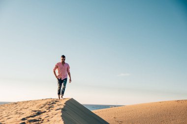 Maspalomas sahilinde yürüyen bir adam Gran Canaria İspanya 'da, Maspaloma' nın kum tepelerinde yürüyen bir adam.