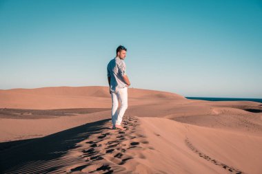 Maspalomas sahilinde yürüyen bir adam Gran Canaria İspanya 'da, Maspaloma' nın kum tepelerinde yürüyen bir adam.